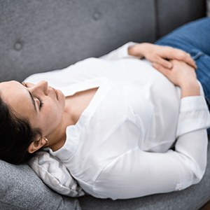 Young woman patient of Balanced Mental Health of Arizona laying on a couch resting.