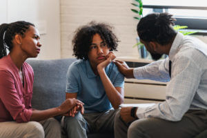 A woman with a teen son is in a meeting with a PTSD counselor.